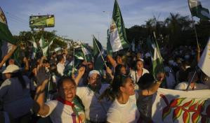 Un grupo de personas posando delante de una multitud de gente con paraguas 4dde0335 focus 0 0 299 176